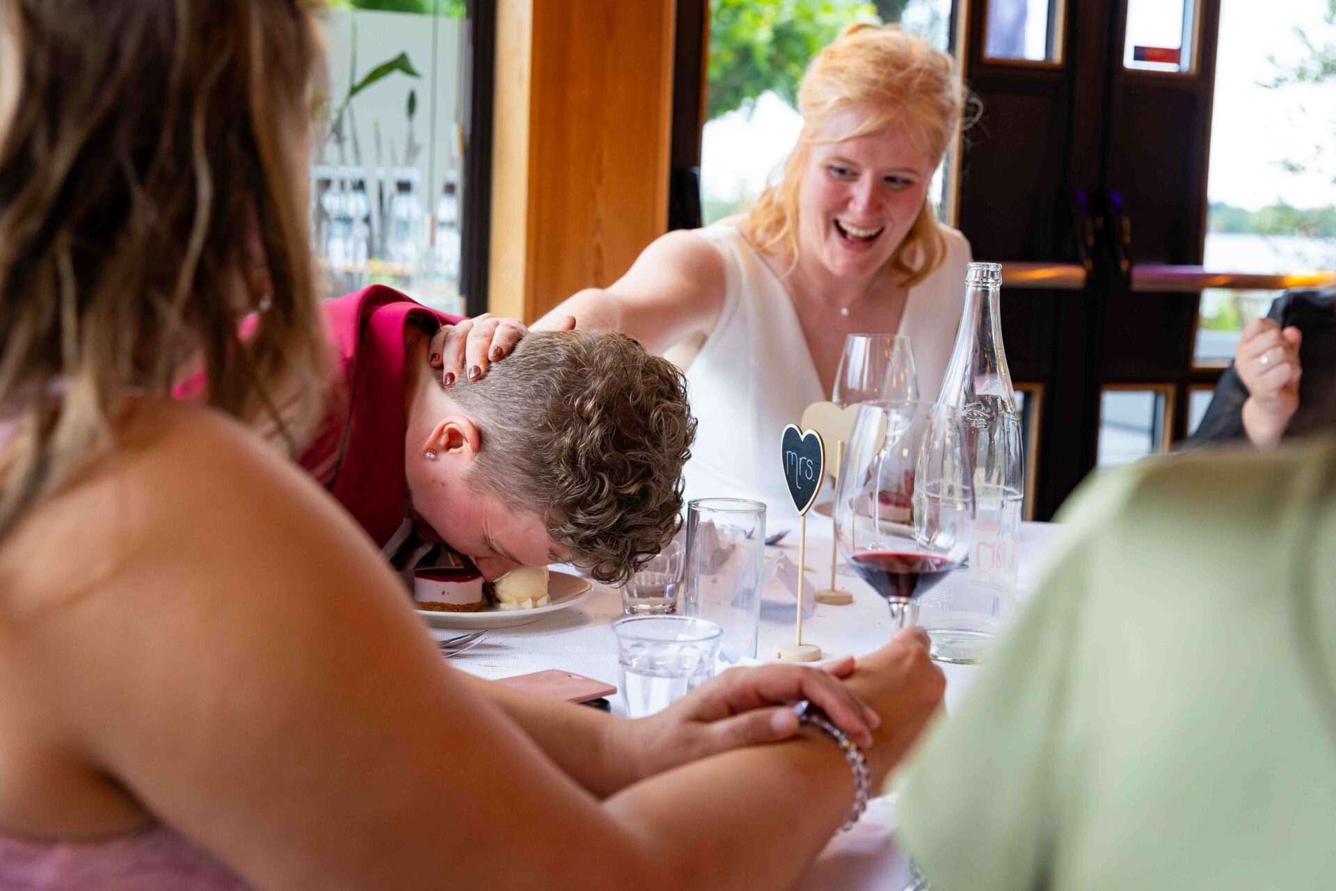 De bruid duwt haar bruid met haar neus in het dessert - Trouwfotograaf Bruidsfotograaf Groningen